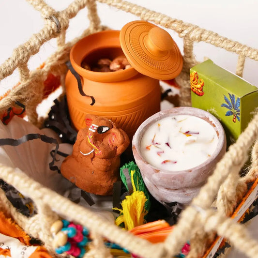 Eco-Friendly Soil Inspired Gift Hamper with Jute Basket, Terracotta Jar of Cashews, Marble Urli, Toran, Playing Cards, Terracotta Candle & Plantable Ganesh The confetti tree