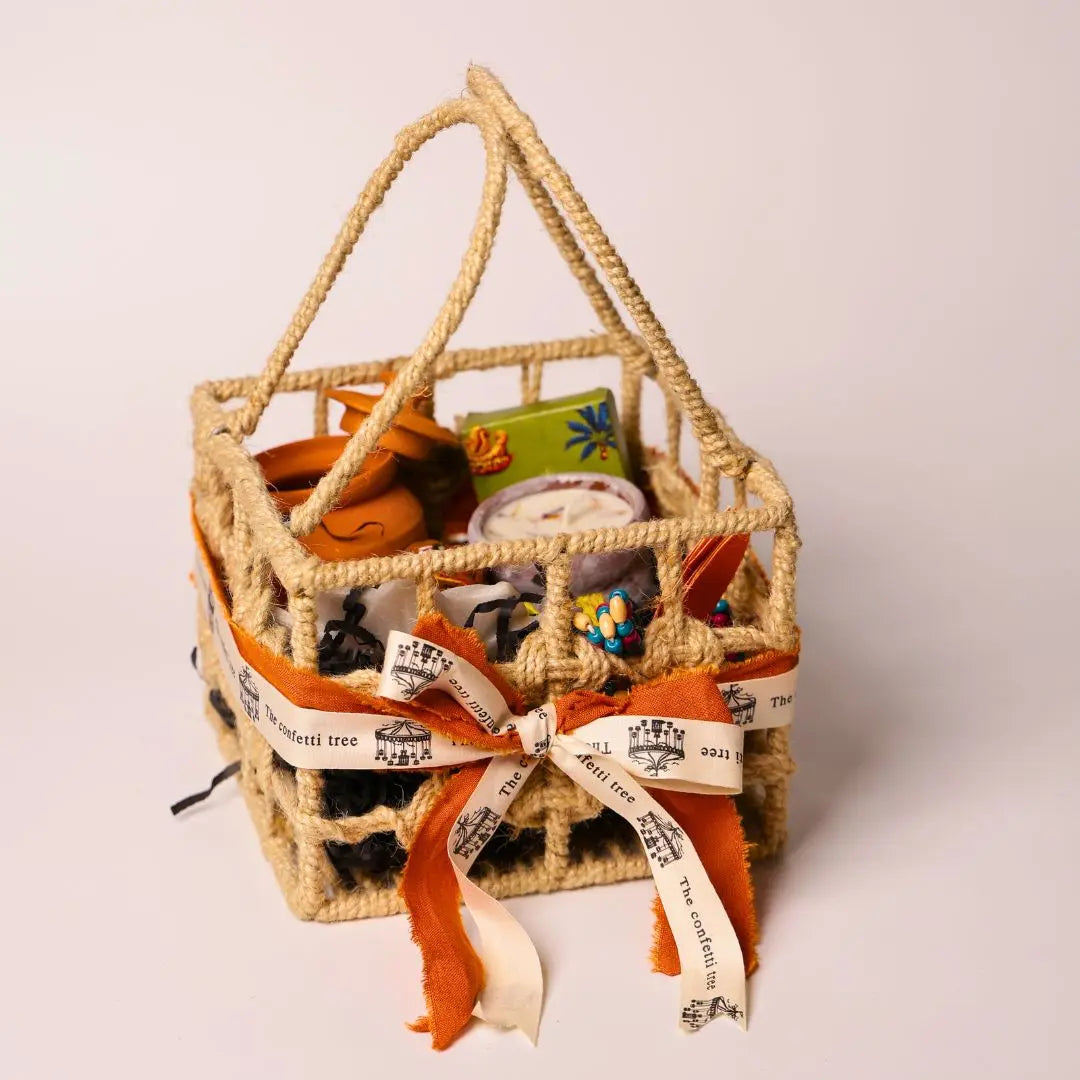 Eco-Friendly Soil Inspired Gift Hamper with Jute Basket, Terracotta Jar of Cashews, Marble Urli, Toran, Playing Cards, Terracotta Candle & Plantable Ganesh The confetti tree