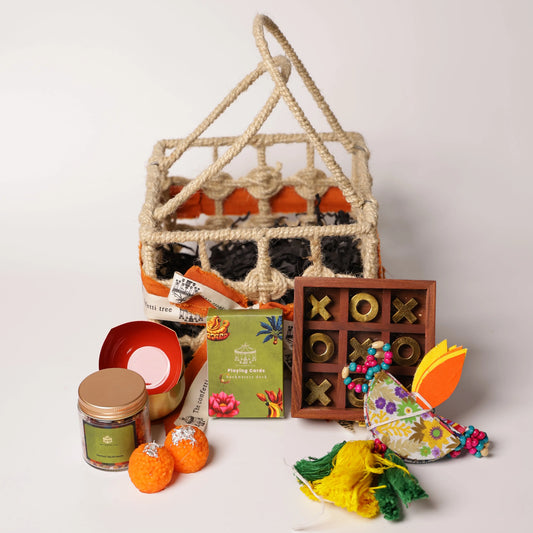 Luxury Jute Gift Basket with Wooden Tic Tac Toe, Brass Diyas, Toran, Laddoo Candles, Mukhwas Jar & Playing Cards – Festive Gifting Hamper The confetti tree