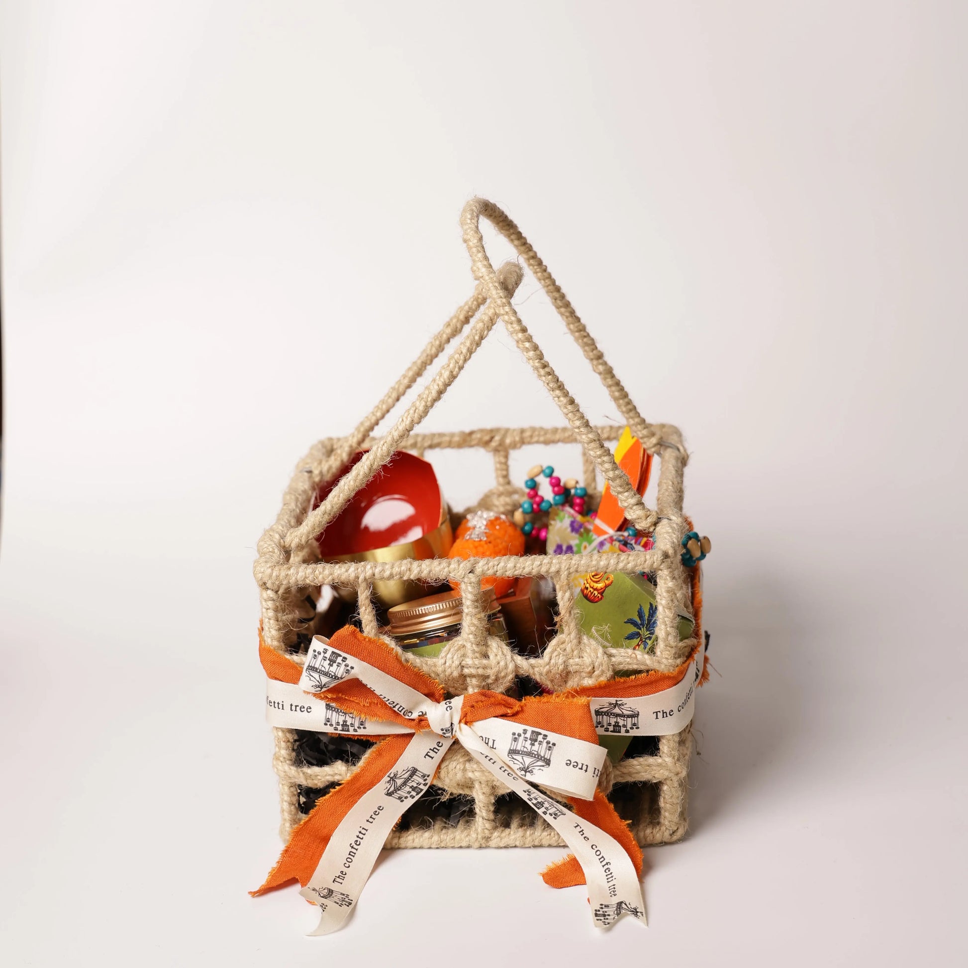 Luxury Jute Gift Basket with Wooden Tic Tac Toe, Brass Diyas, Toran, Laddoo Candles, Mukhwas Jar & Playing Cards – Festive Gifting Hamper The confetti tree