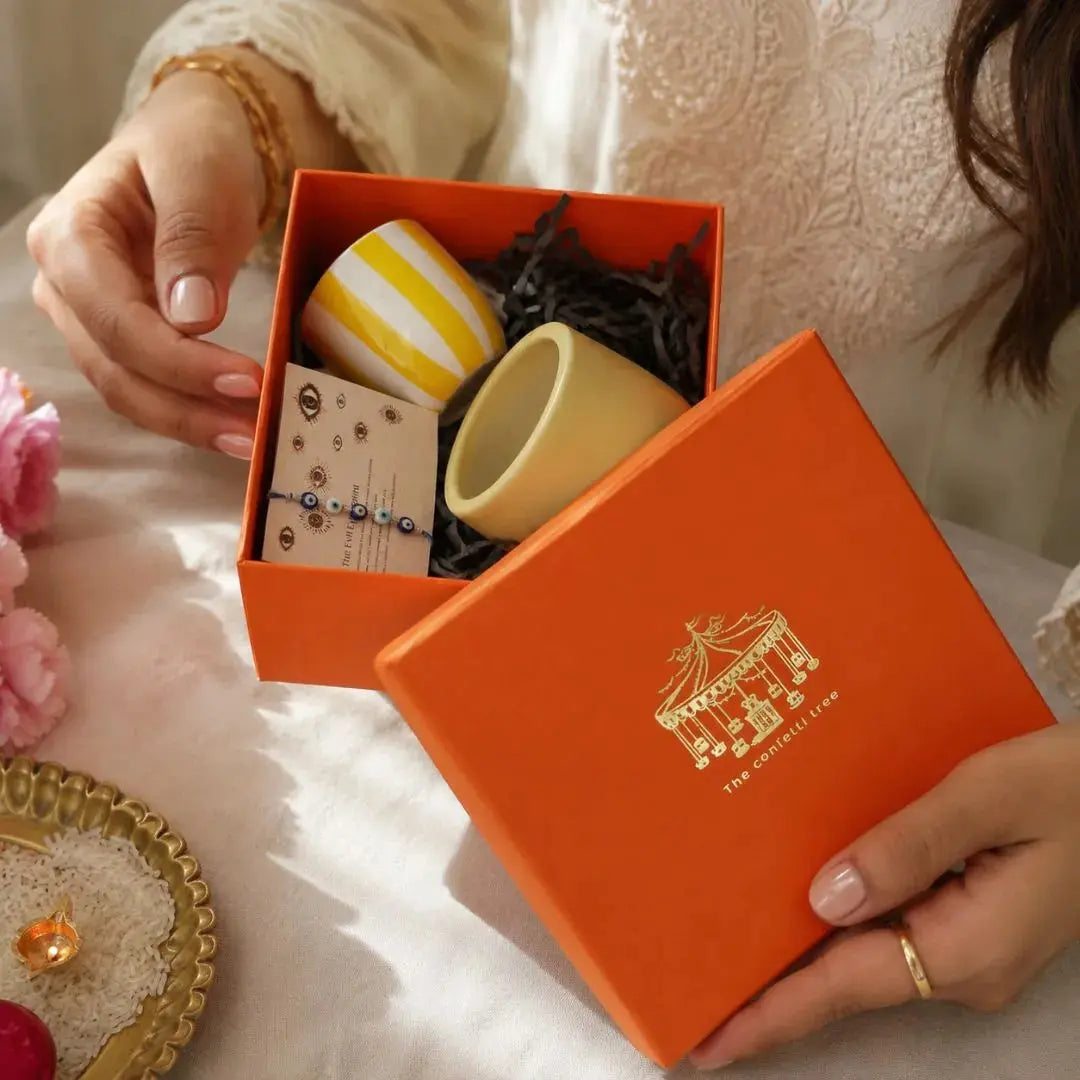 Premium Rakhi Gift Hamper with Evil Eye Rakhi & Lumba, Ceramic Planter, Stoneware Coffee Mug & Greeting Card | Luxury Raksha Bandhan Gift Box for Bhai & Bhabhi The confetti tree