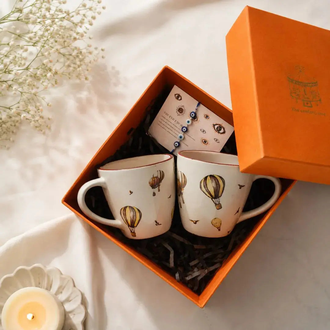 Premium Rakhi Gift Hamper with Evil Eye Rakhi & Lumba, Set of 2 Whimsical Hot Air Balloon Ceramic Coffee Mugs & Greeting Card | Luxury Raksha Bandhan Gift Box for Bhai & Bhabhi The confetti tree