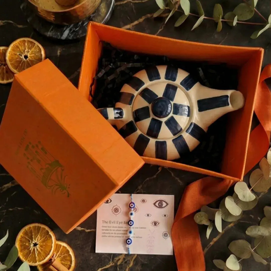 Rakhi Gift Hamper with Evil Eye Rakhi & Lumba & Handpainted Teal Kettle with  TealTea Cup Set | Premium Raksha Bandhan Gift for Bhai Bhabhi The Confetti Tree